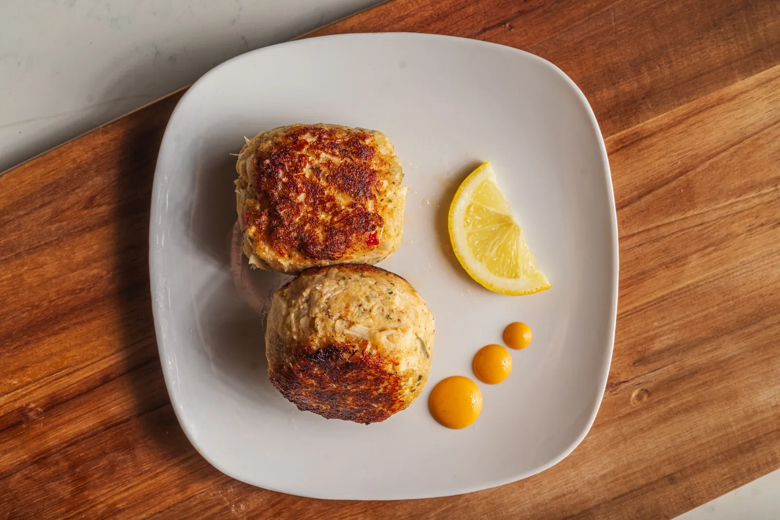 Crab cakes on a wooden board