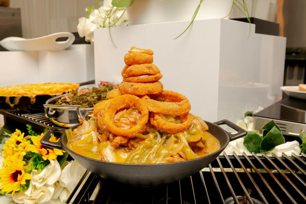 A tower of onion rings on a smothered dish