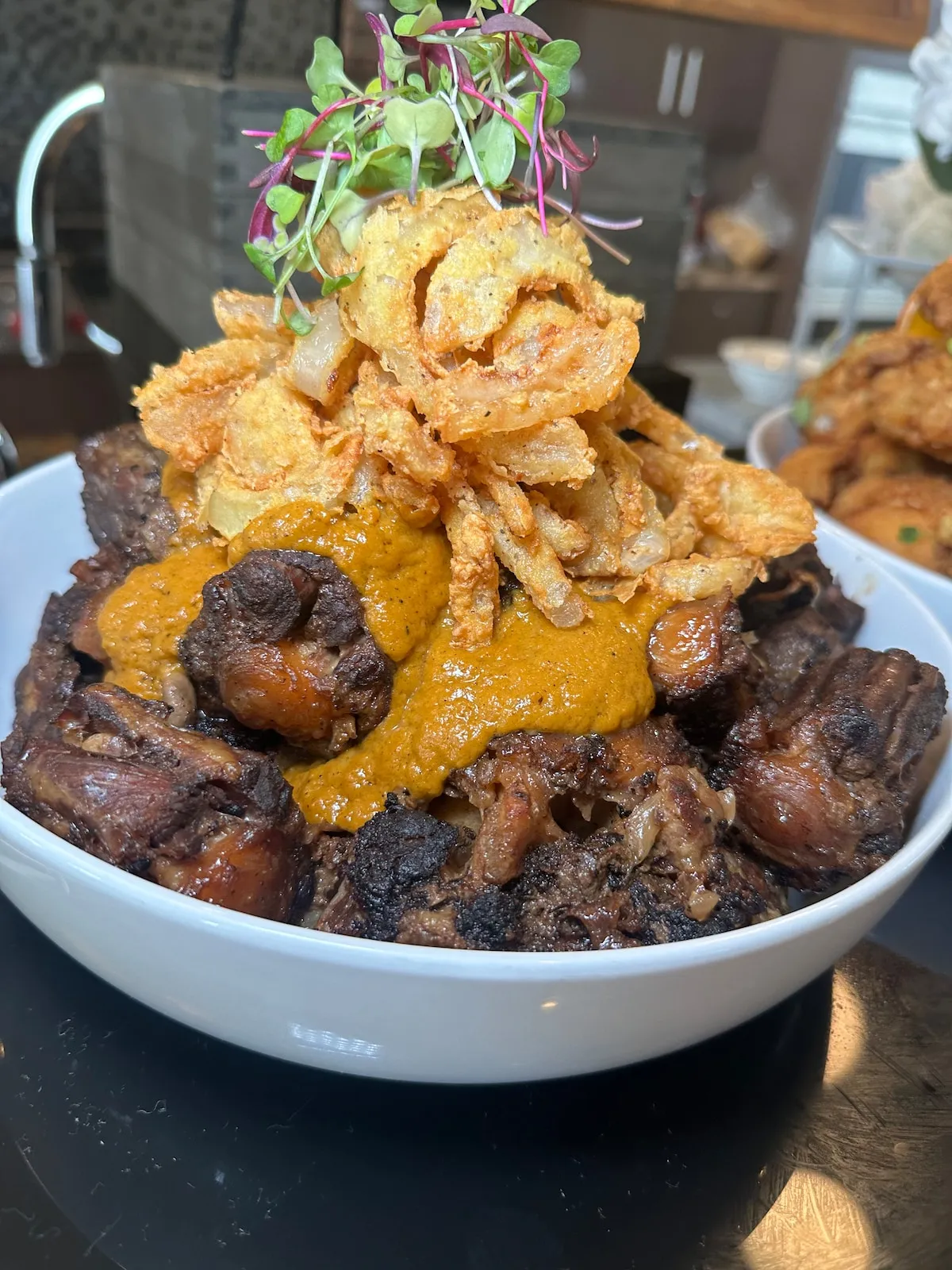 Brown stew oxtails topped with crispy onions