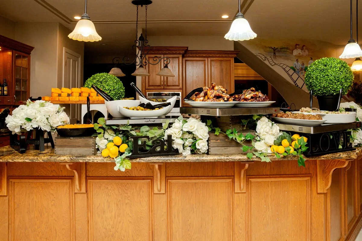 A party spread laid out on a kitchen island with flowers