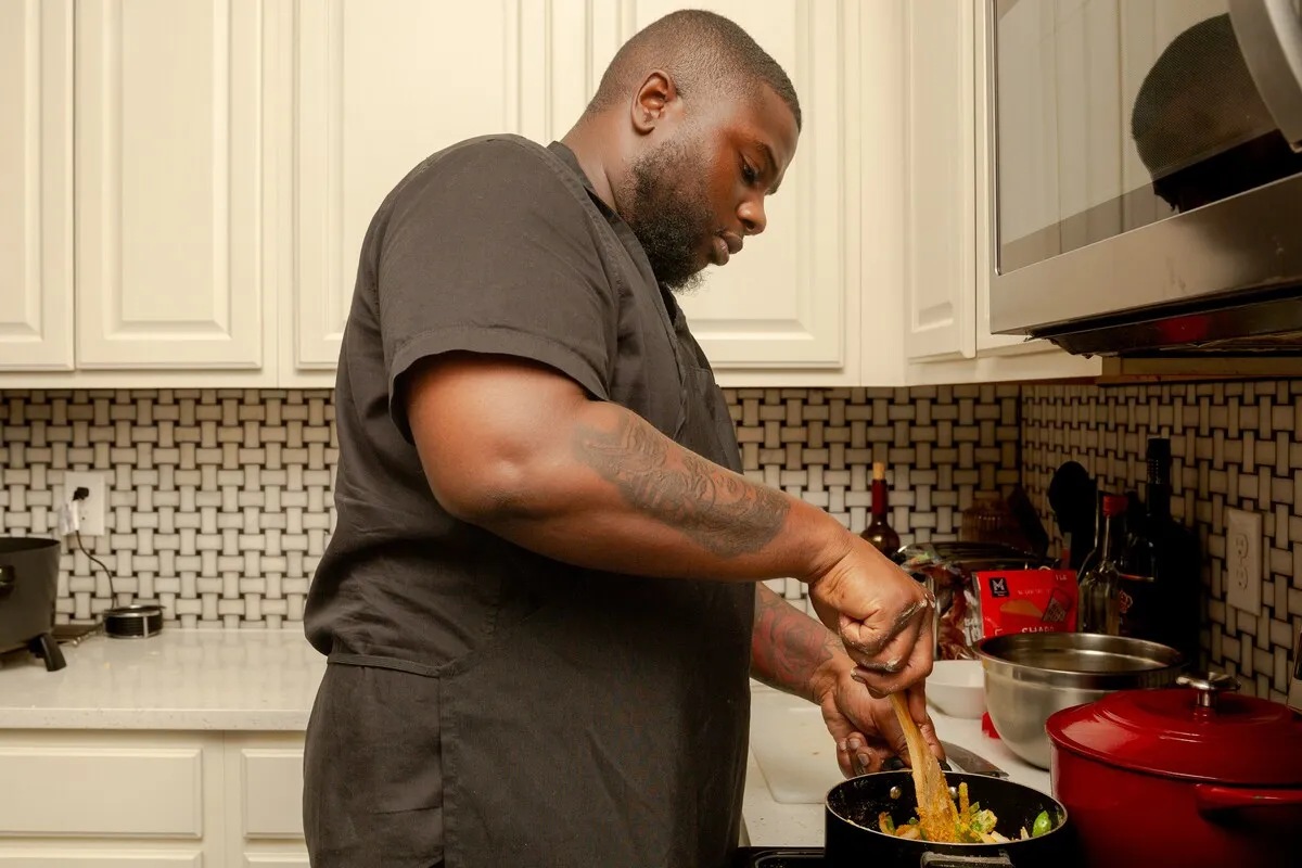Tony stirring a pot in his Chef Tony Tone apron